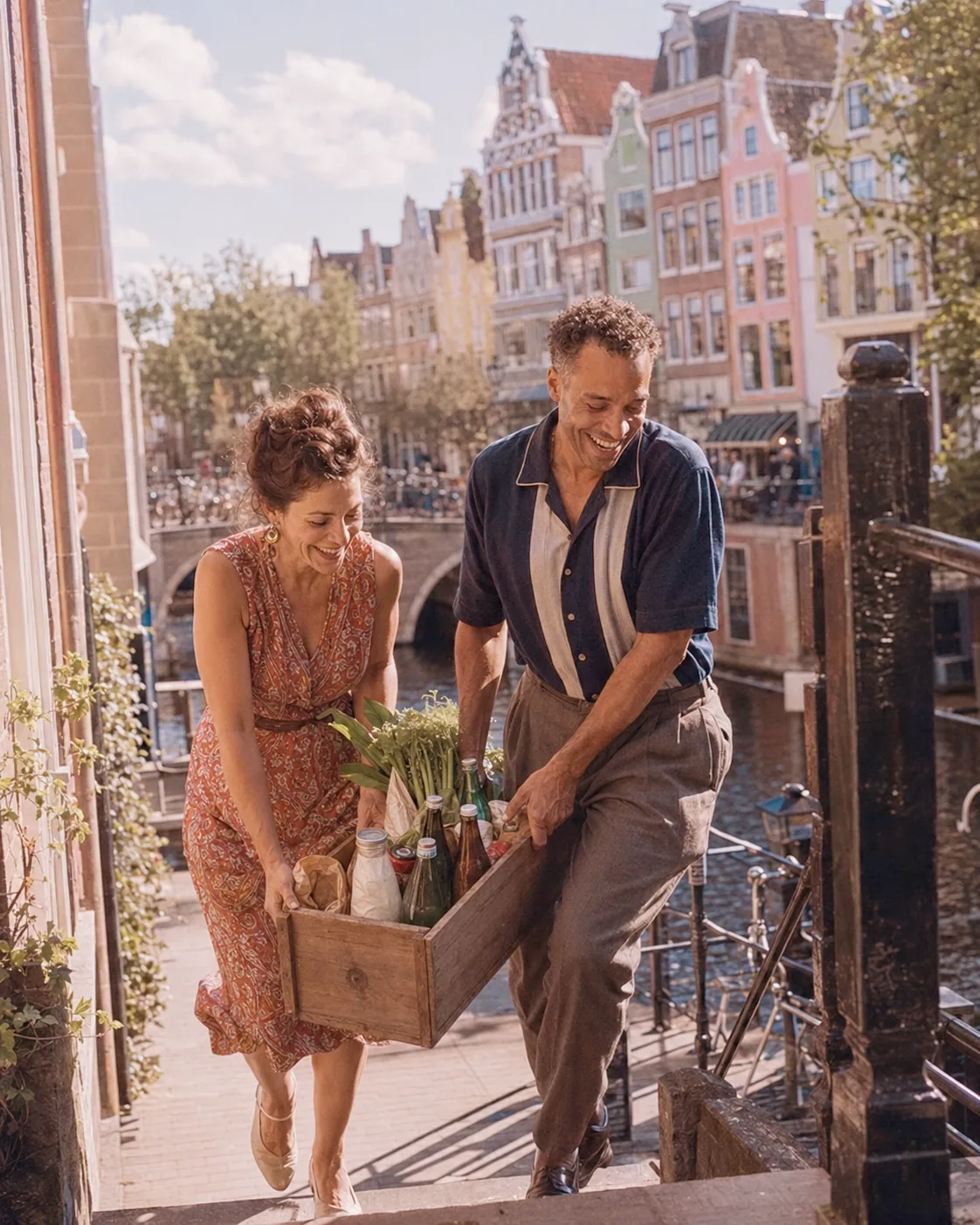 Koppel sjouwt een krat met verse boodschappen door een Amsterdamse straat
